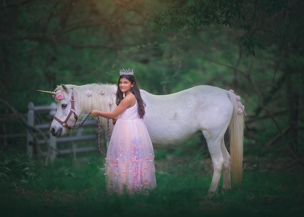 Girl laughing while standing with a unicorn during a birthday photoshoot in Mullica Hill NJ captured by a New Jersey photographer.
