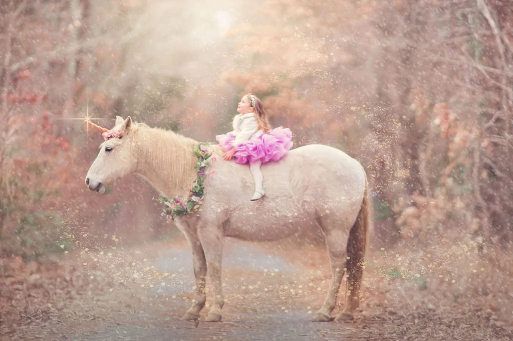 girl-pink-dress-sitting-on-unicorn-portrait.jpg