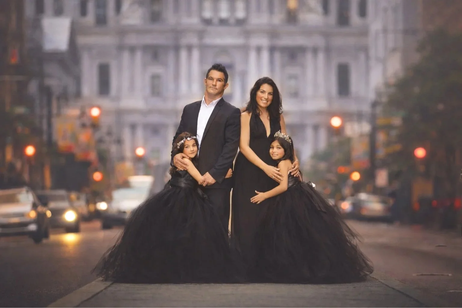 A fine art family portrait photographed at twilight in Philadelphia, blending emotional connection with an editorial, cinematic style. Timeless and intentional portrait with energy of the city captured