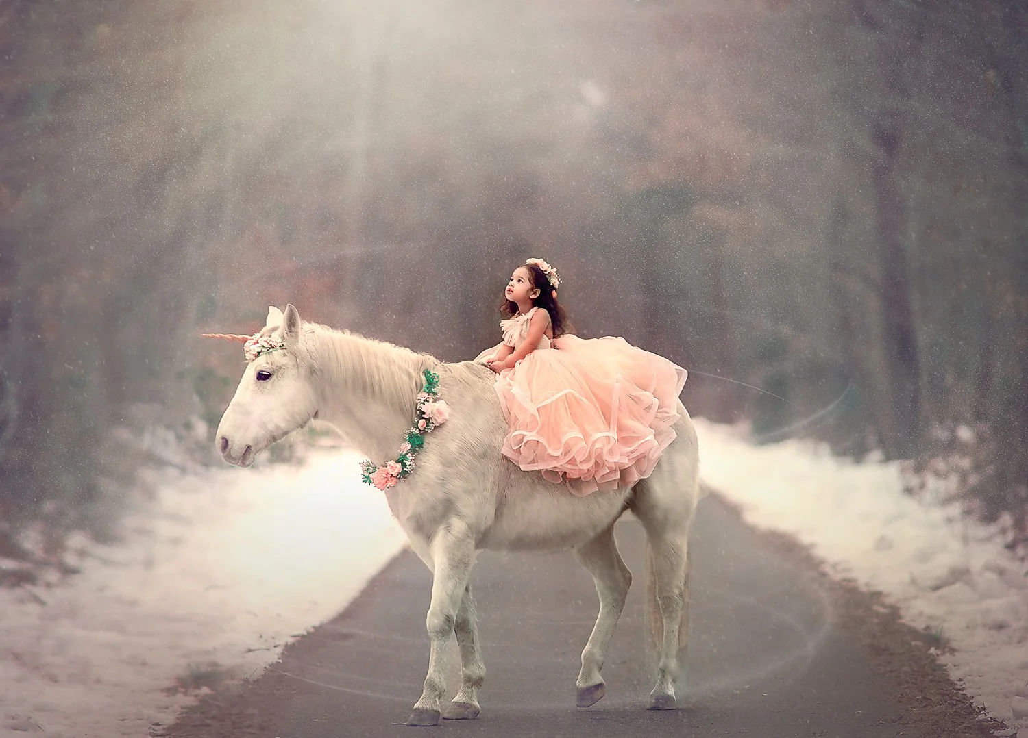 A young girl sitting on top of a unicorn during a winter unicorn portrait session, surrounded by a calm, storybook atmosphere.
