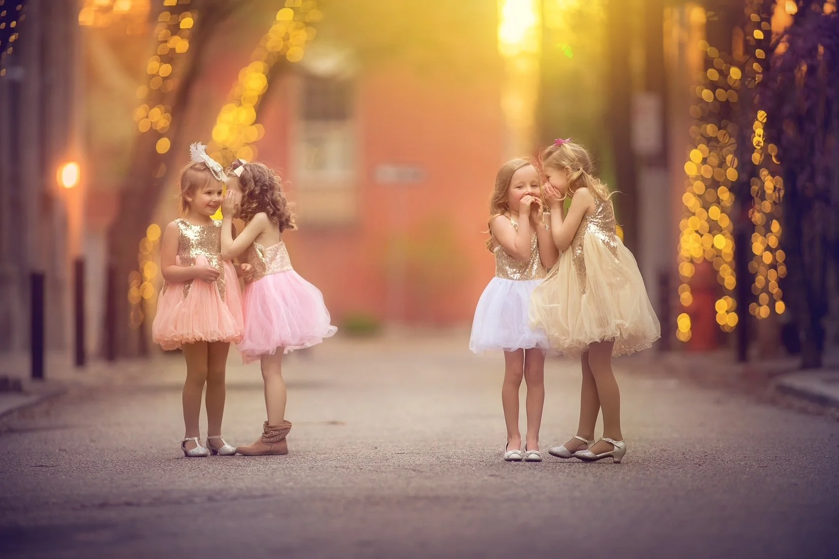 Four friends leaning together and sharing secrets during a child portrait session in Philadelphia.