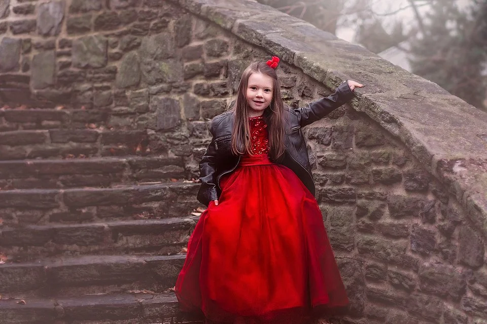 A fine-art Valentine’s portrait of a little girl in a red dress posed on timeless stone stairs, created for Valentine’s photography sessions in New Jersey and Philadelphia.