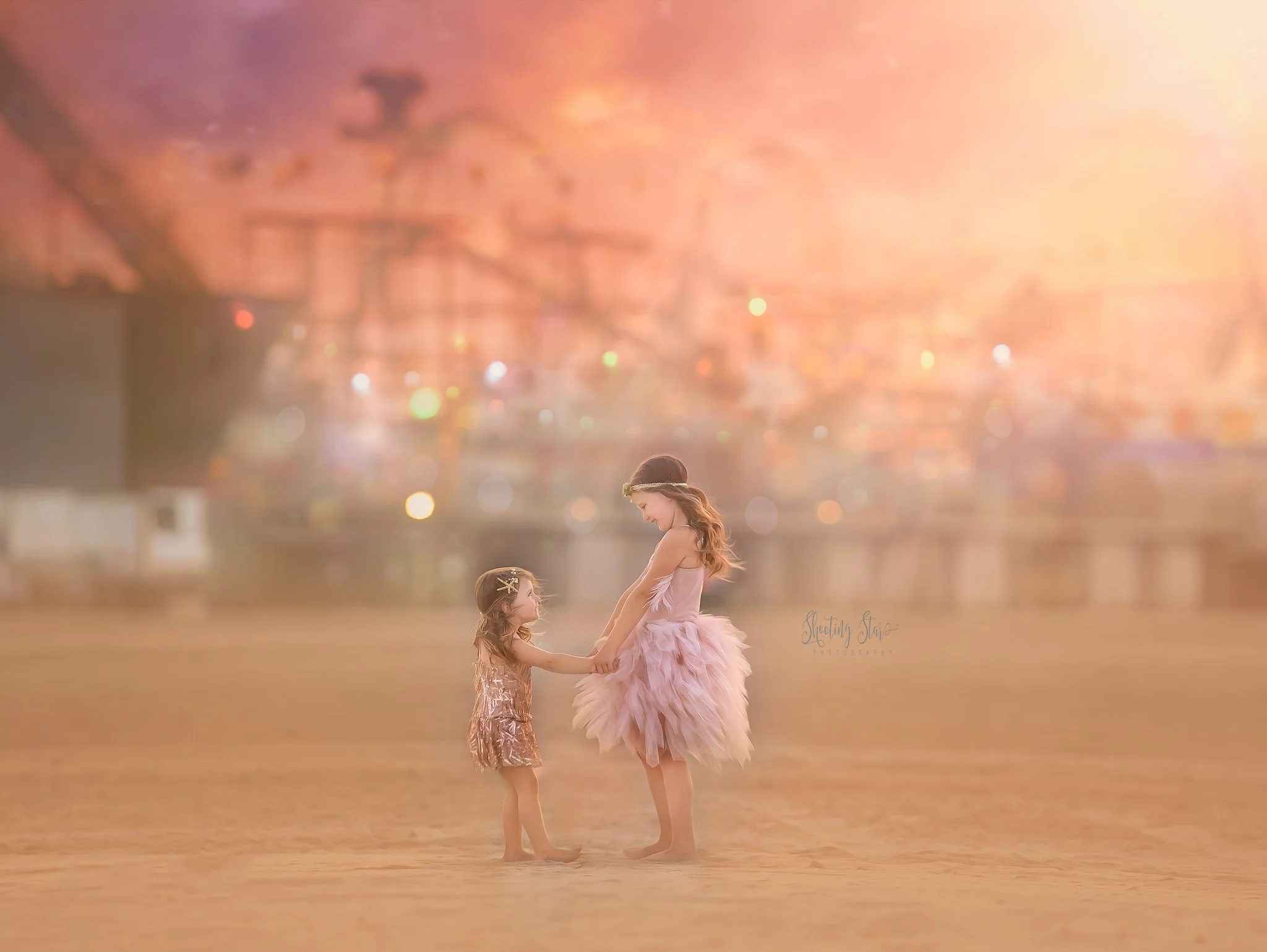 Two sisters smiling together with the Wildwood roller coaster in the background during a beach portrait session in Wildwood, New Jersey