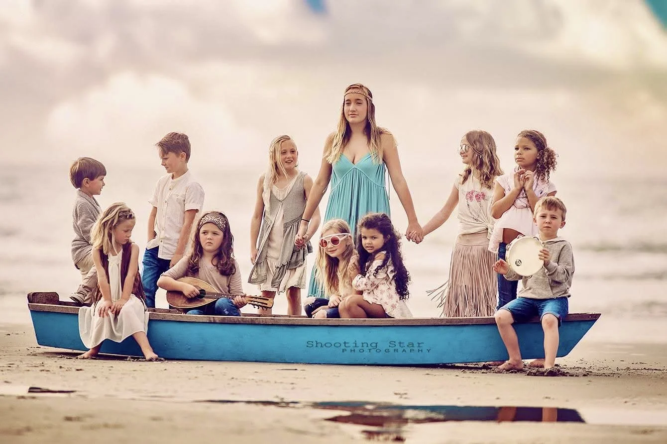 Boho-inspired photoshoot at the Jersey Shore with kids in a boat, guitars, and playful hippy accessories