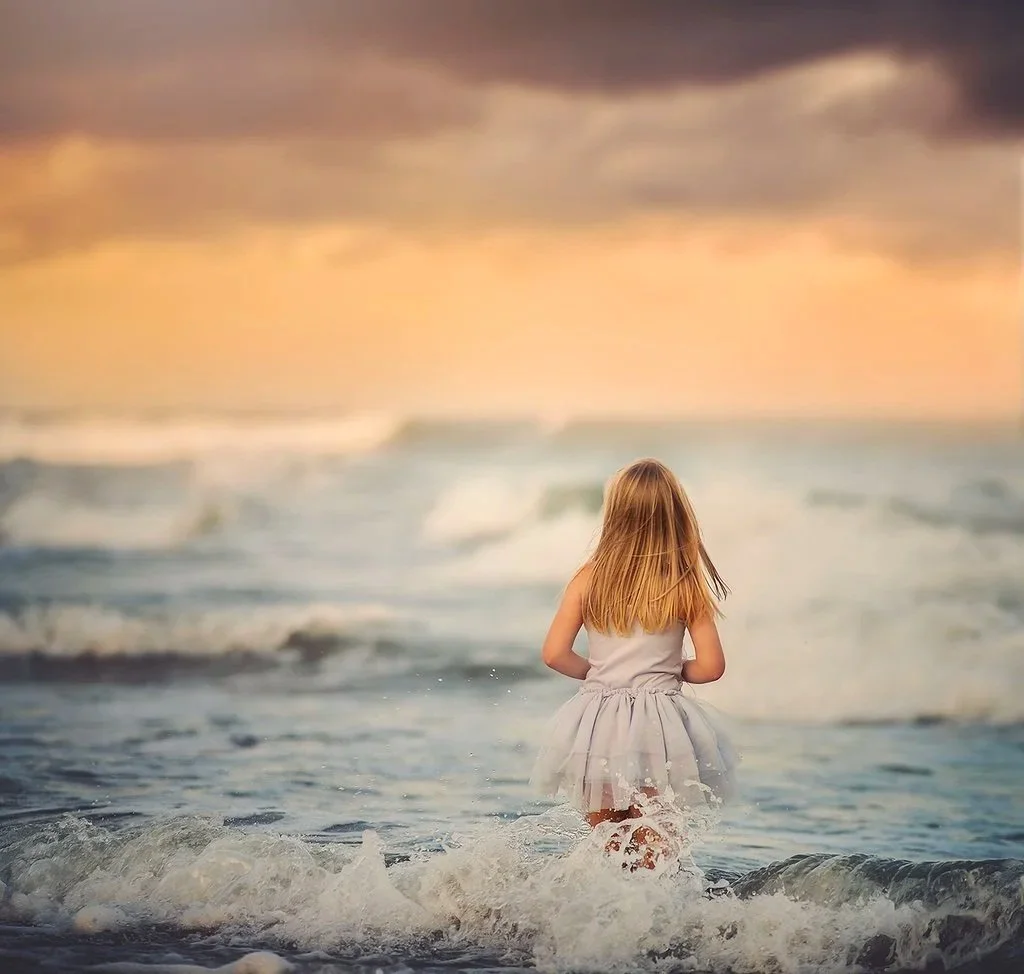 Girl standing on the beach looking out at the ocean in Atlantic City, New Jersey during a Jersey Shore portrait session