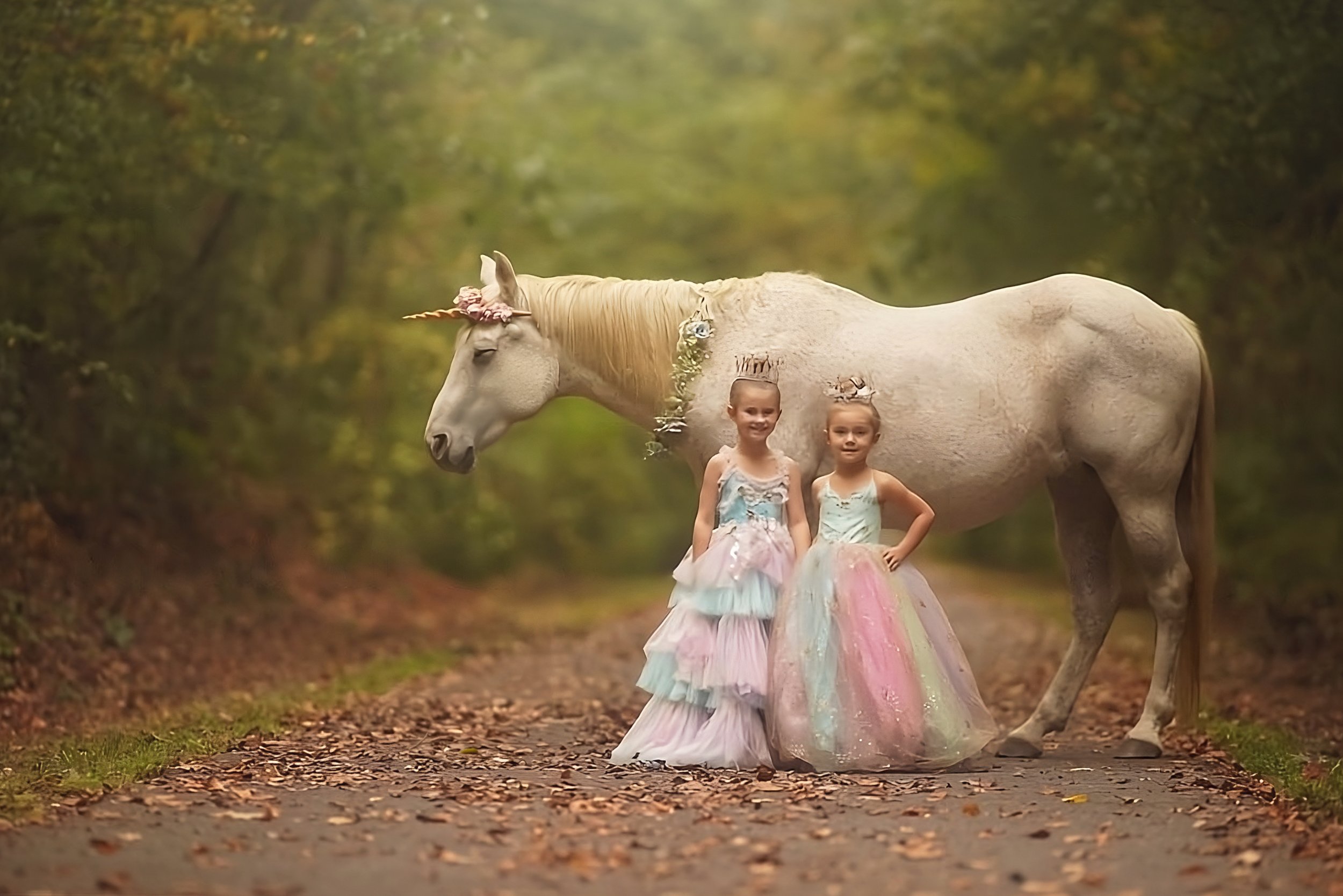 Two sisters smiling at the camera during a unicorn birthday photography session in South Jersey