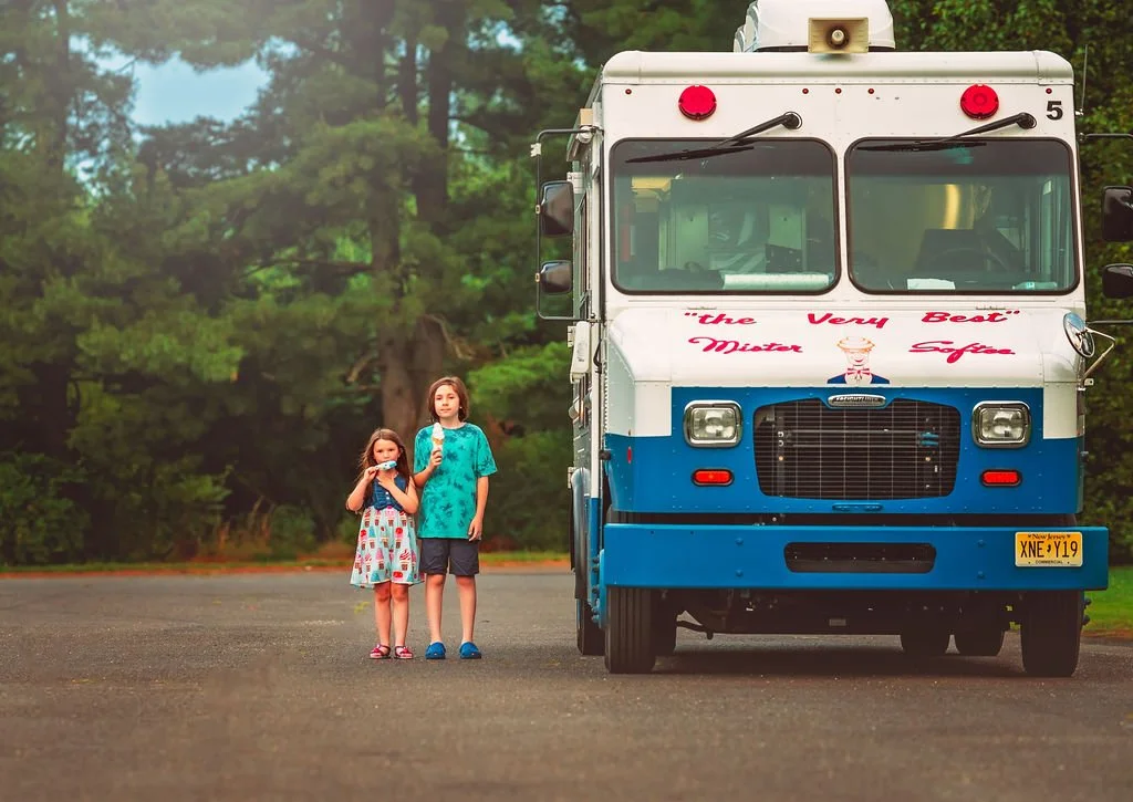 Children’s faces lit up with joy as they enjoy their ice cream on a summer day.