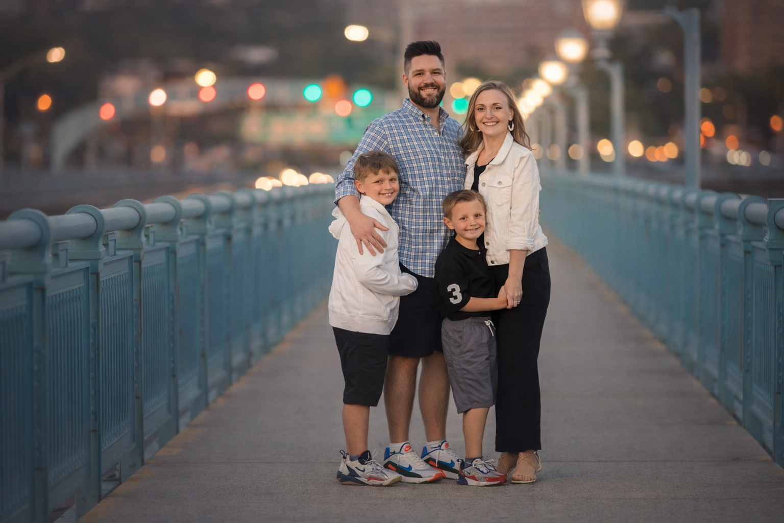 Parents and their two sons during a family portrait session by the Ben Franklin Bridge.