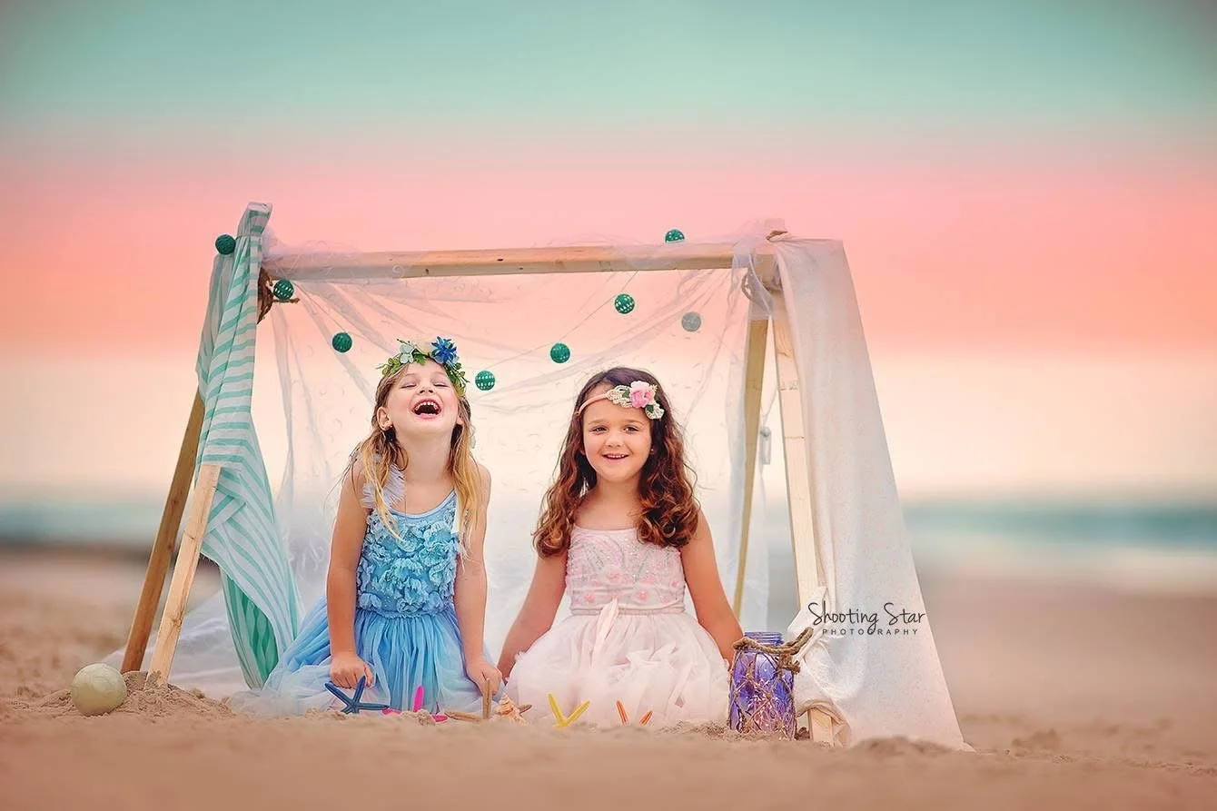 A candid Cape May family portrait of children laughing inside a beach tent