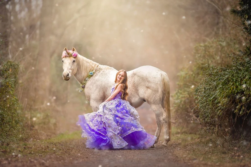 Young girl in flowing purple gown during winter unicorn portrait session in South Jersey snow-covered landscape