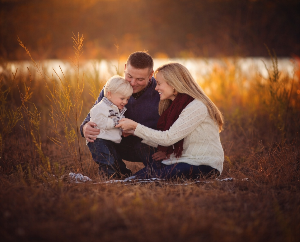 family session in a field in new jersey with mom, dad, and their toddler son a beautiful moment shared between them
