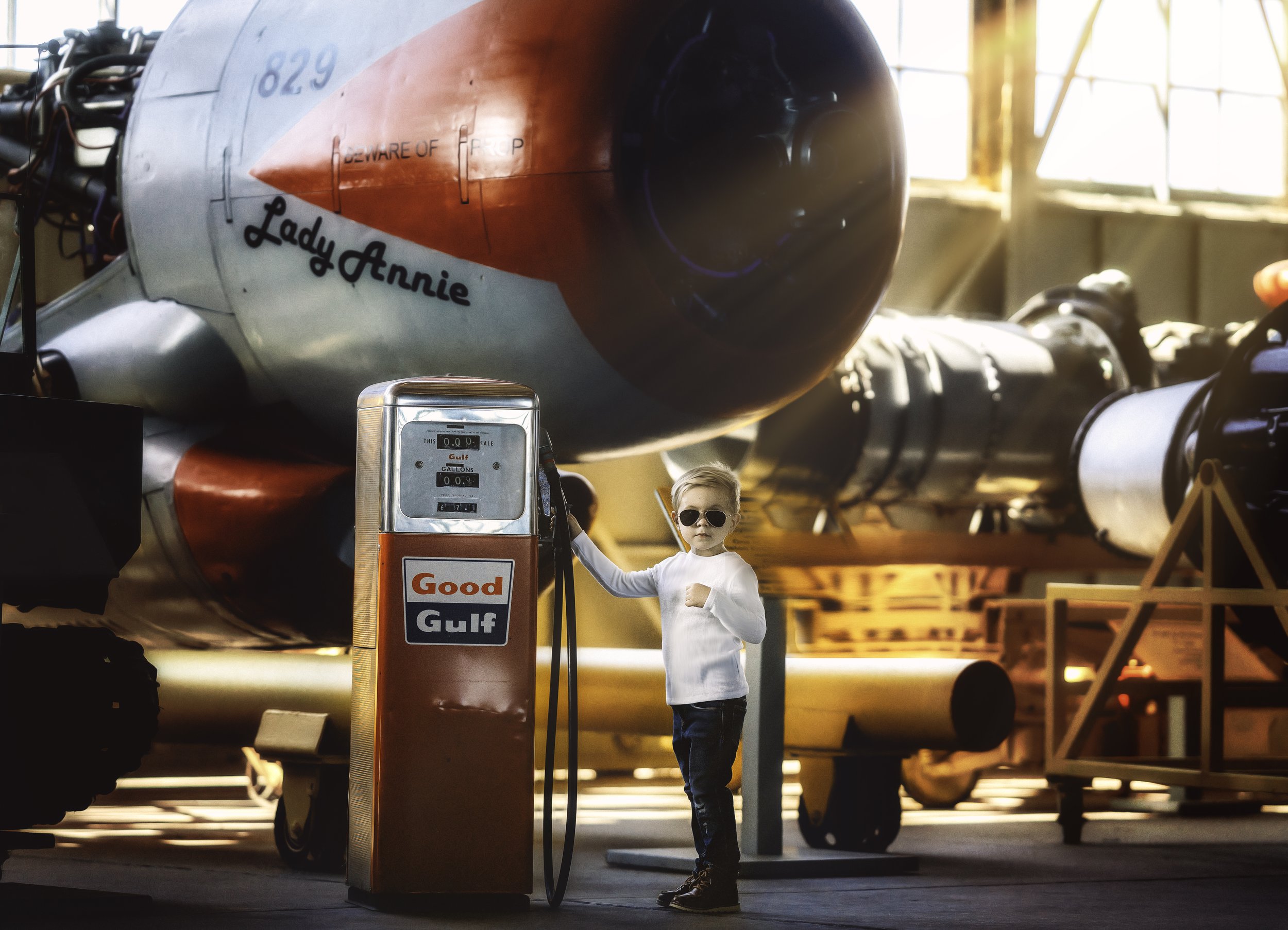 Child in jeans posing next to vintage gas pump at Naval Air Station Wildwood aviation museum New Jersey