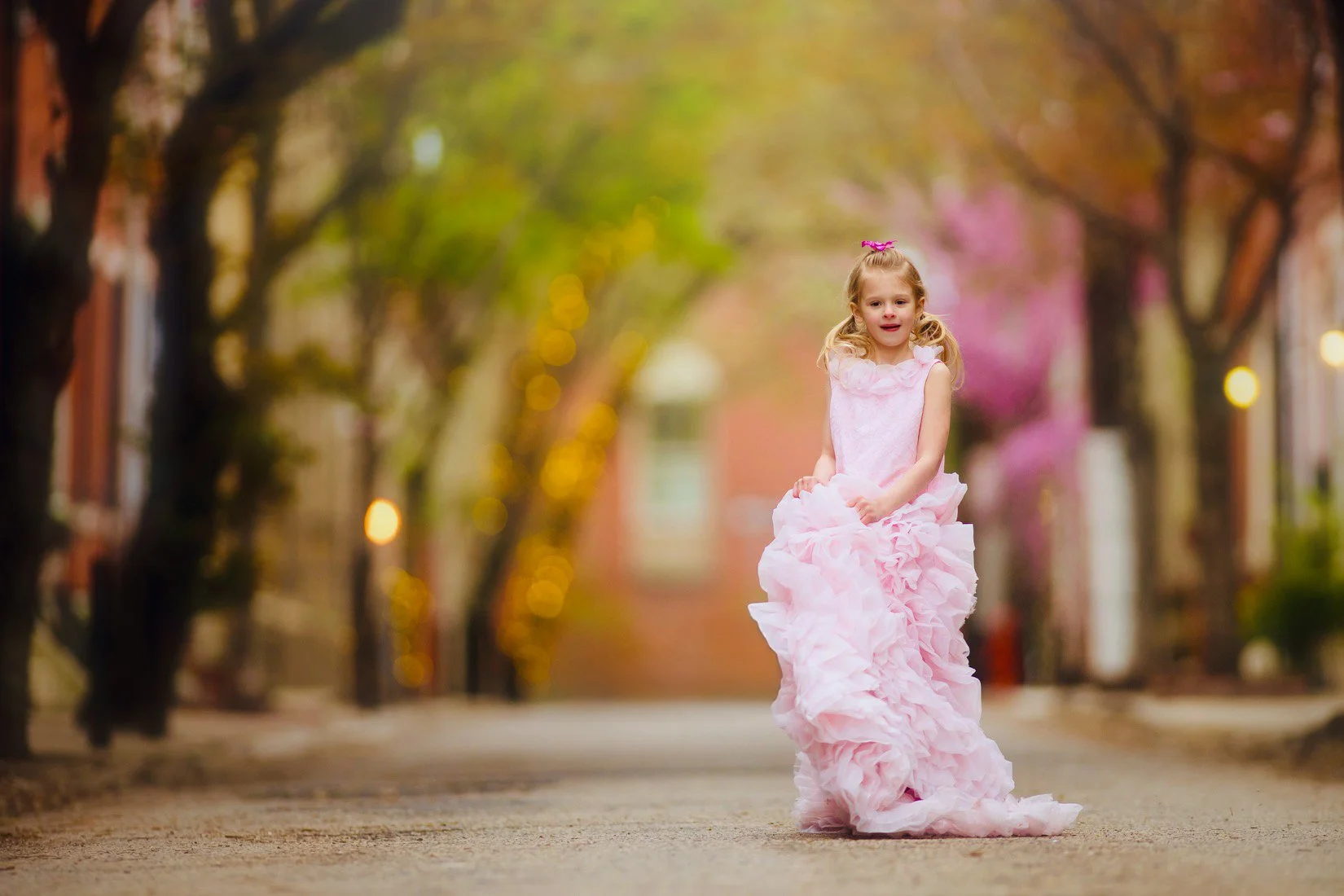 Girl in a pink dress twirling during a child portrait session in Philadelphia.