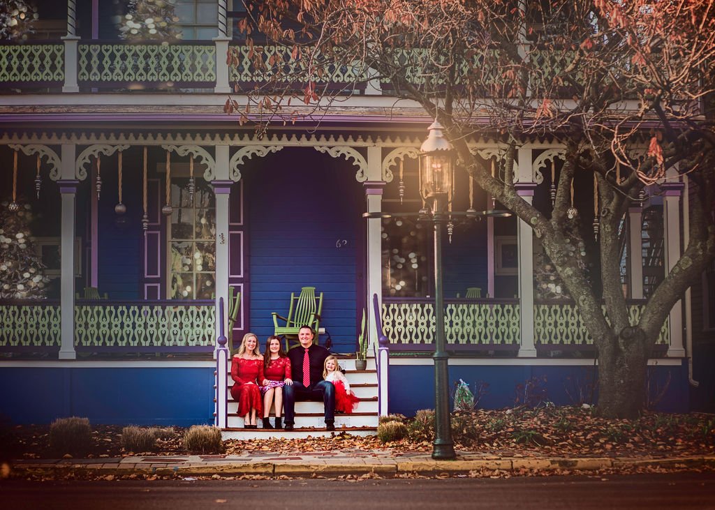 Family dressed in holiday outfits during Christmas portraits in Cape May New Jersey photographed by a family photographer.
