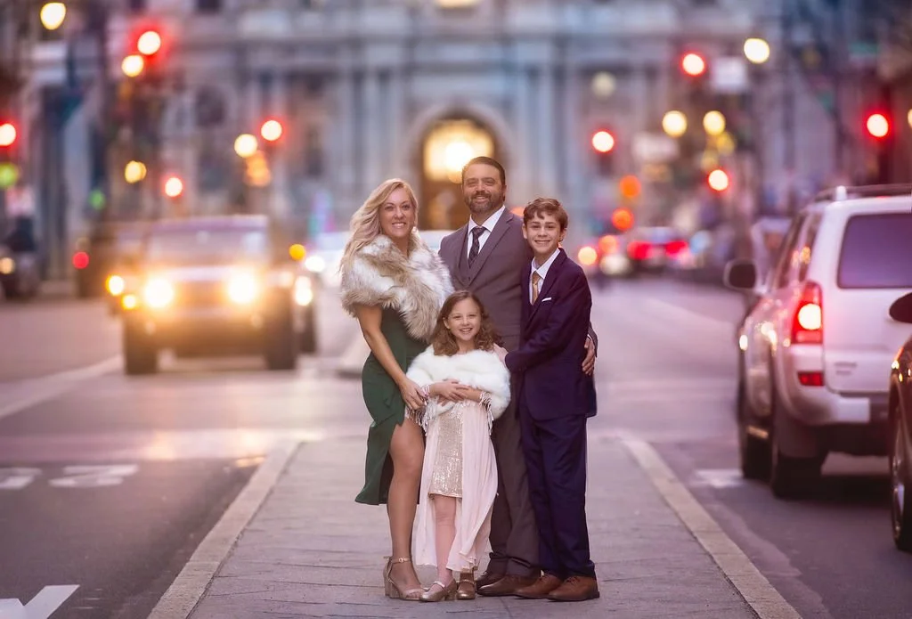 Family standing together for a portrait in Center City Philadelphia during an evening family photography session.
