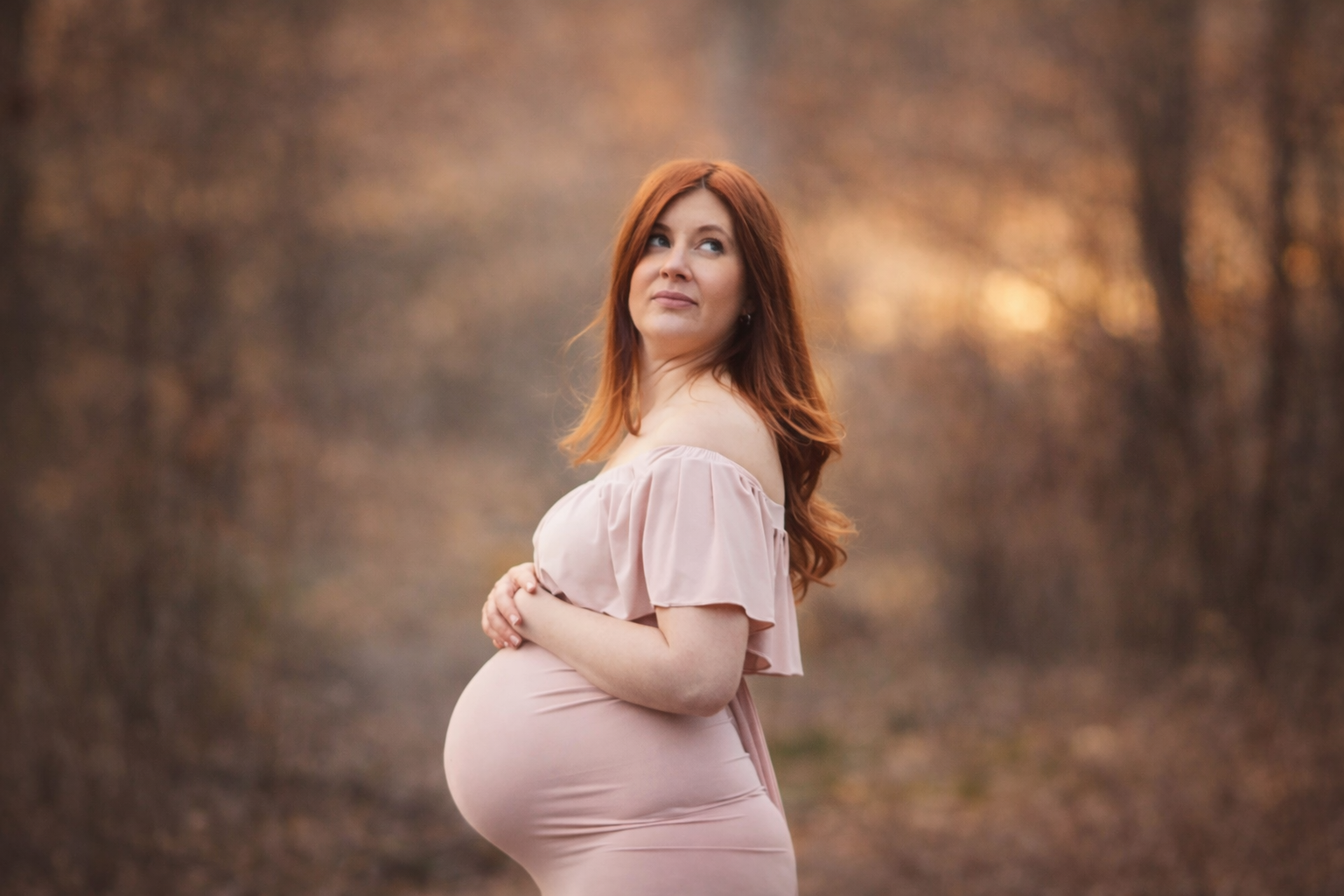 beautiful red head in a cream maternity gown for a maternity portrait session outside philadelphia