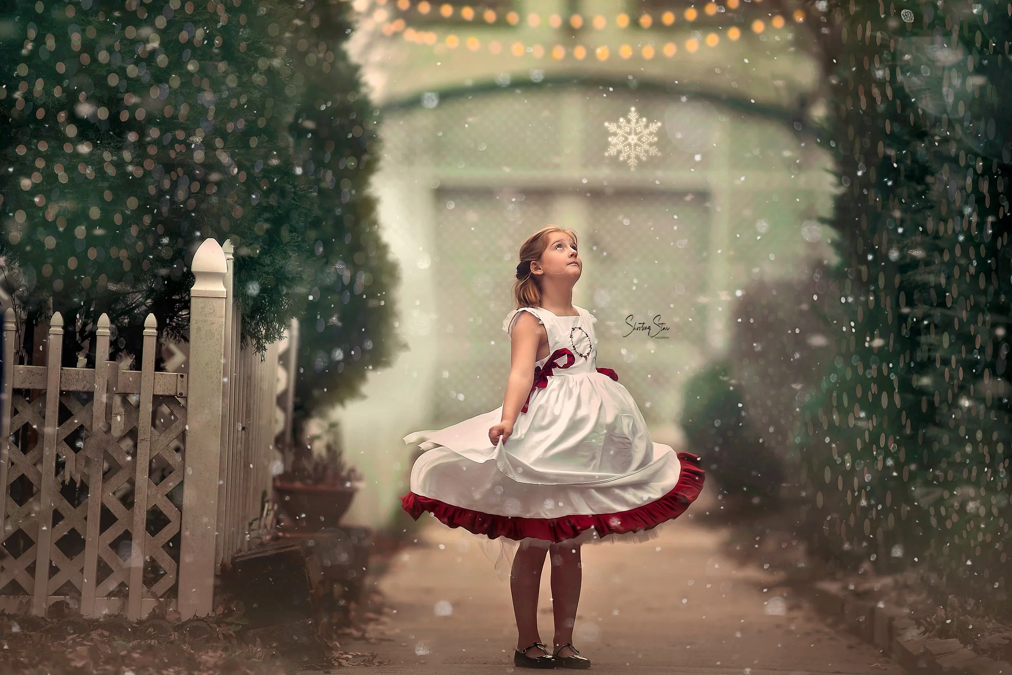 Child in white dress twirling in soft snowfall in Pitman New Jersey during a winter portrait session