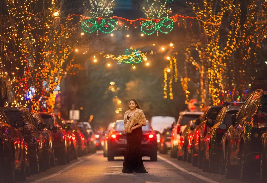 young girl in burgundy dress posing on decorated South Philadelphia street