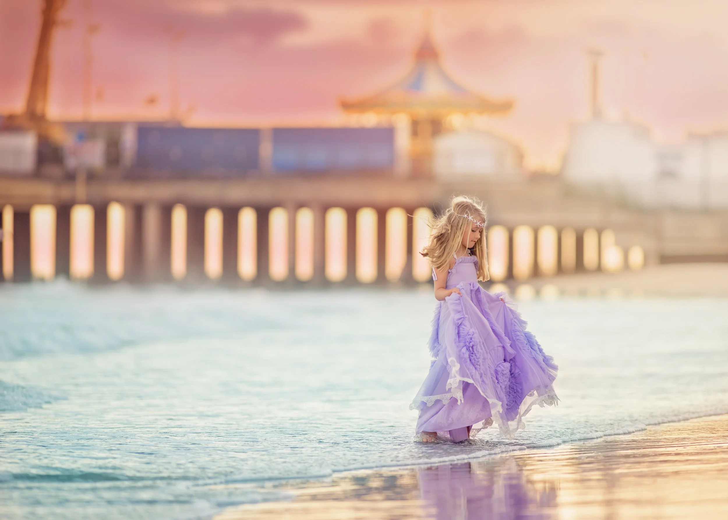 Girl wearing a purple dress standing along the shoreline during a Jersey Shore portrait session