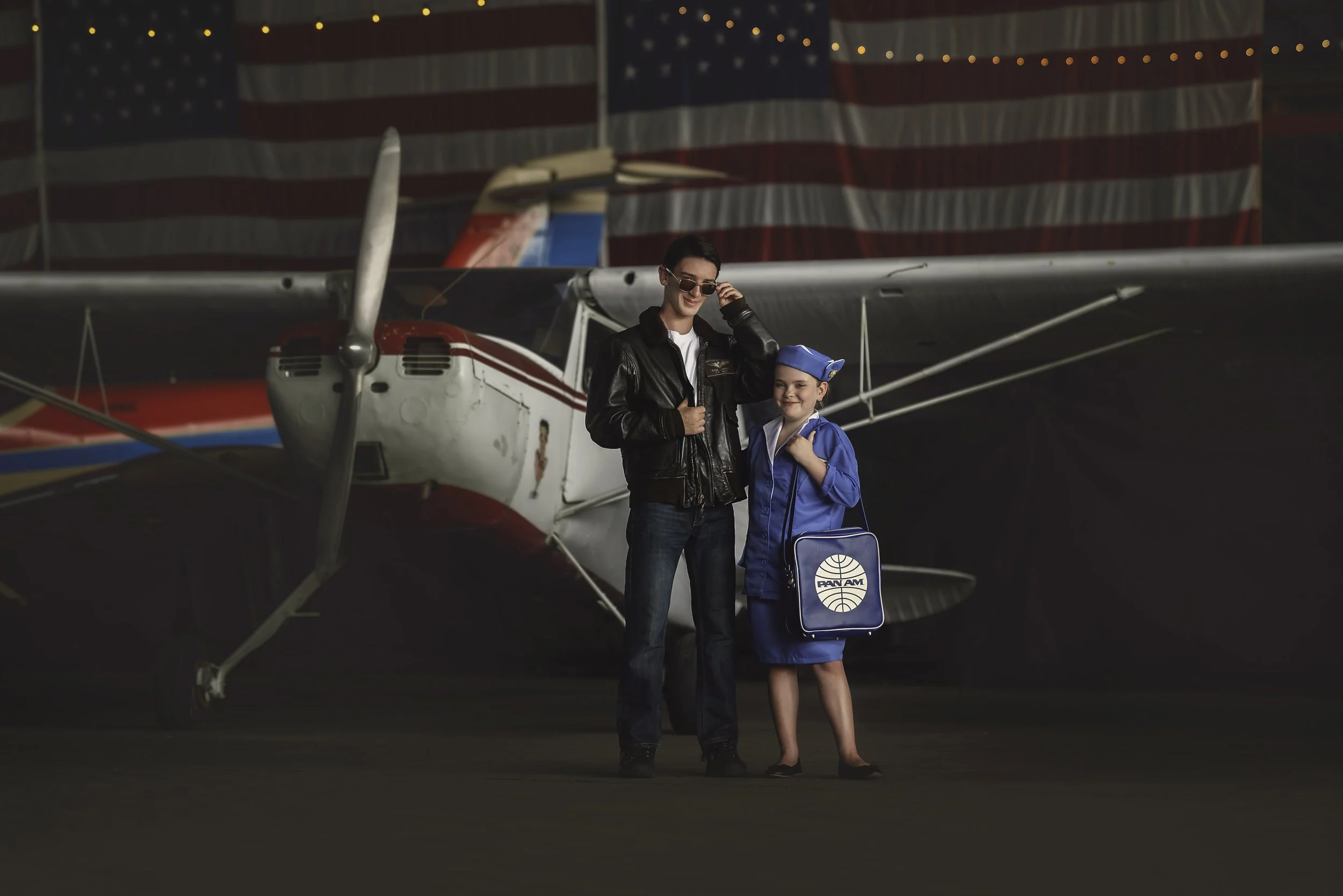 Brother and sister smiling in front of vintage aircraft at Naval Air Station Wildwood New Jersey