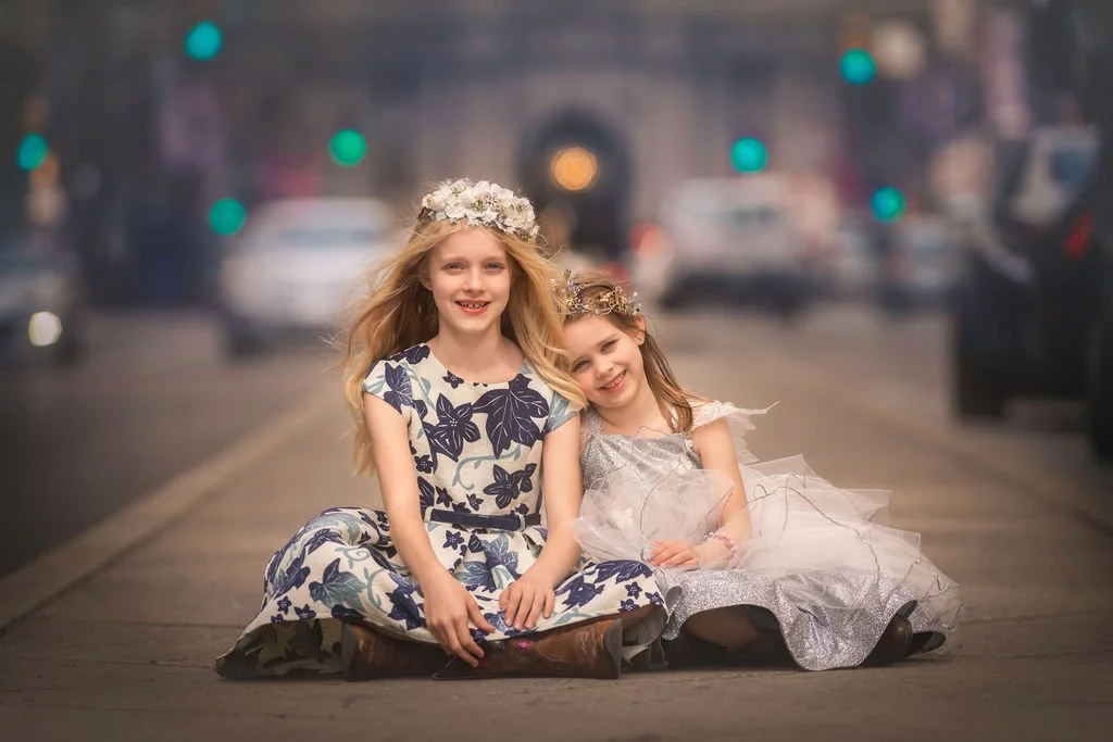 Two girls posing and smiling together during a family portrait session on Broad Street in Philadelphia.