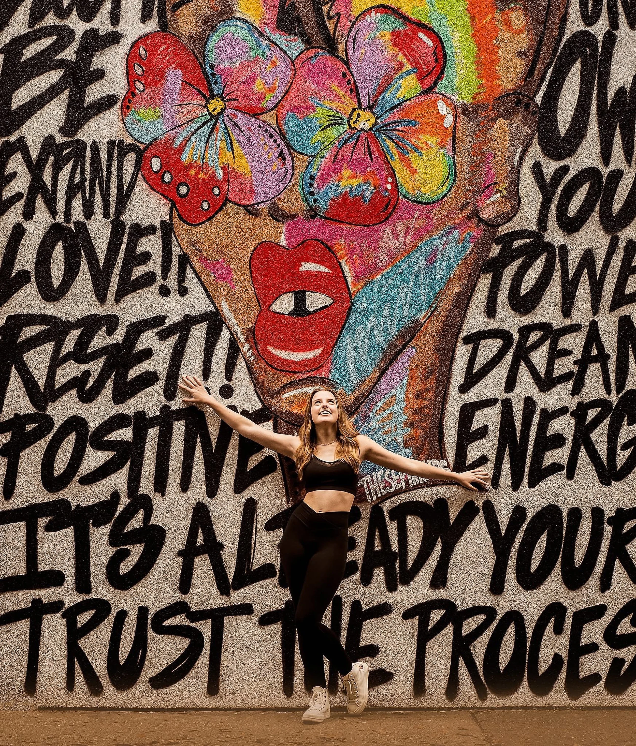 Teen girl posing in front of a colorful graffiti wall during an urban portrait session near Philadelphia Pennsylvania