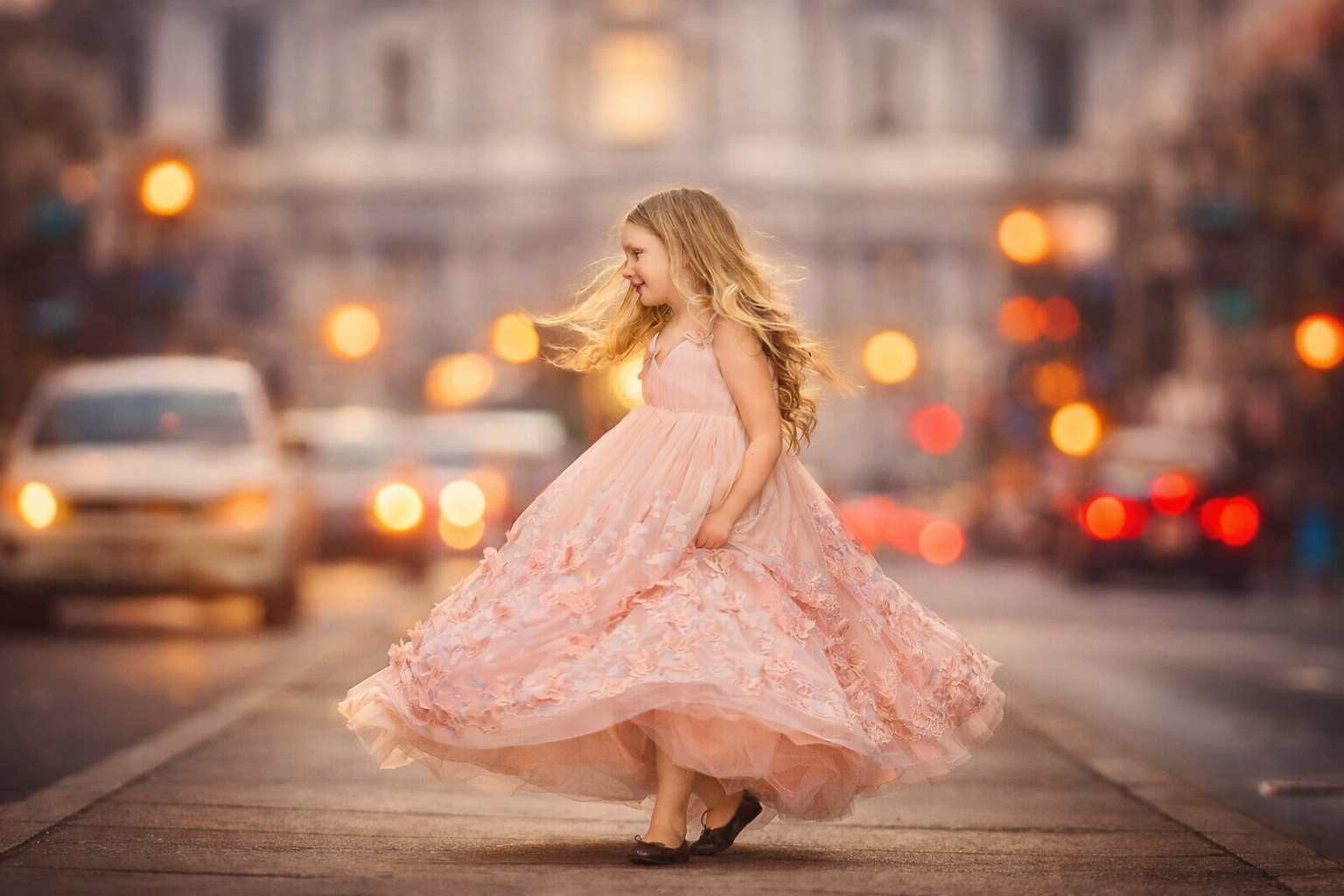 A fine art portrait photographed on Center City in Philadelphia, known for its historic charm and glowing evening lights. The dramatic gown creates a fairytale atmosphere while still feeling grounded and modern—perfect for editorial-style kids portra