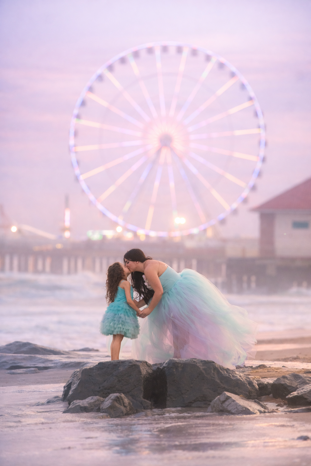 Mom kissing her daughter during a Jersey Shore beach portrait session by a NJ family photographer.