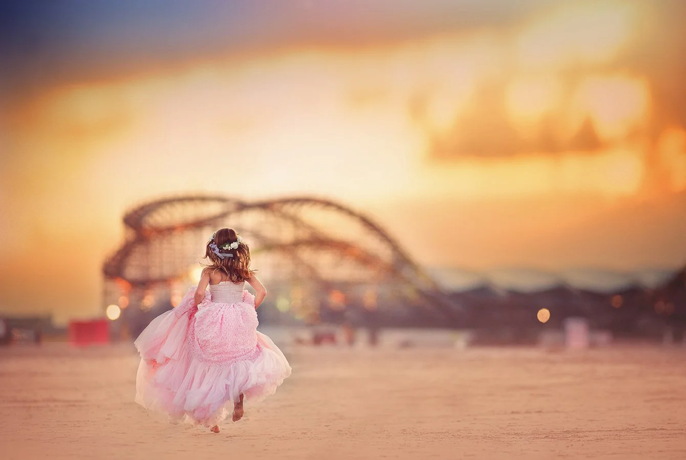 Girl running along the beach in Wildwood, New Jersey toward the pier during a Jersey Shore portrait session