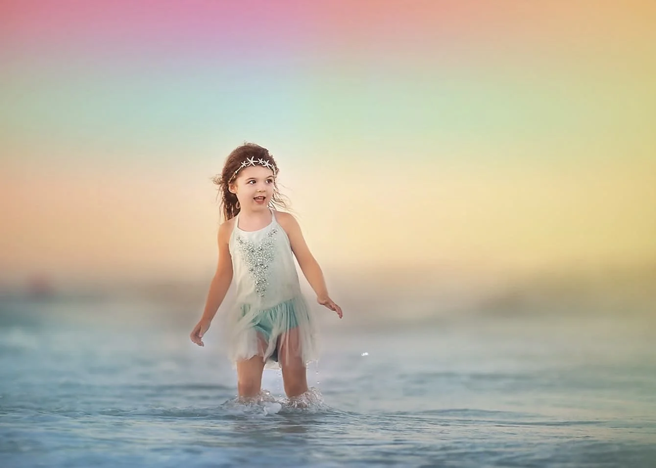 Little girl playing in the ocean during a beach photography session in Ocean City NJ