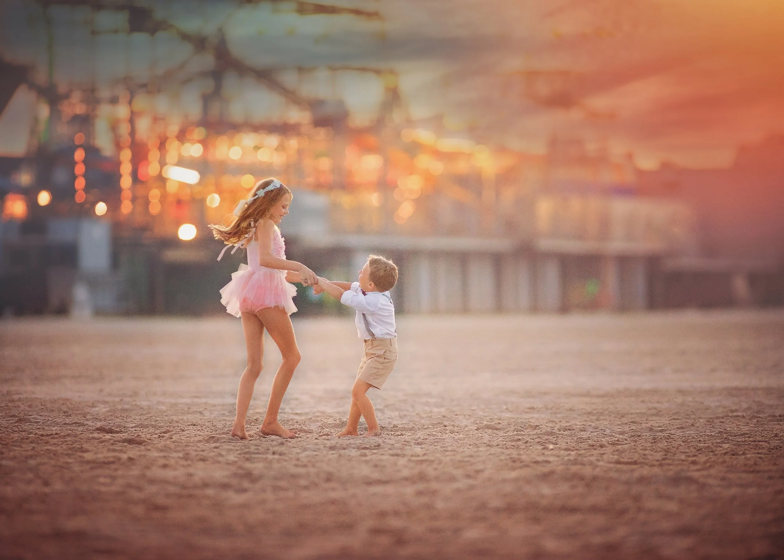 Kids playing on the beach with Morey’s Pier in the background during a sibling portrait session in Wildwood New Jersey photographed by a Jersey Shore family photographer.