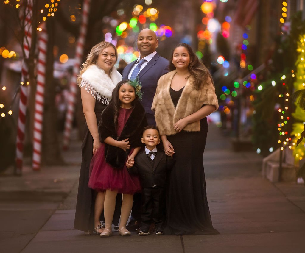family posing together on decorated Philadelphia street during Christmas season
