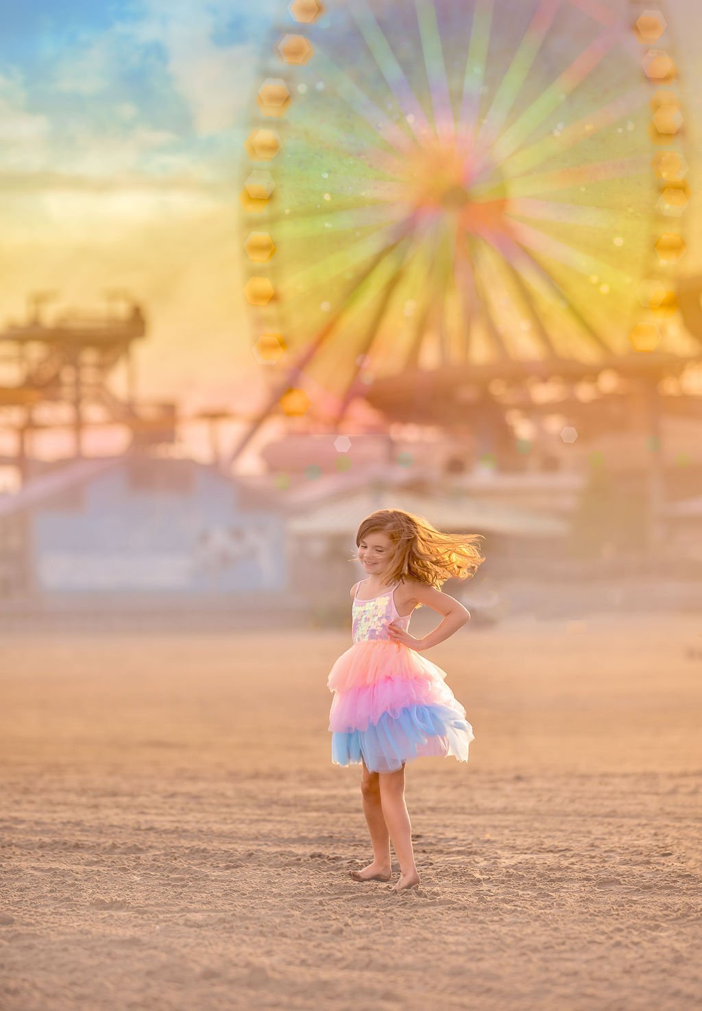 Girl smiling and twirling in the sunlight on Wildwood Beach, wearing colorful rainbow clothes with a roller coaster in the background.