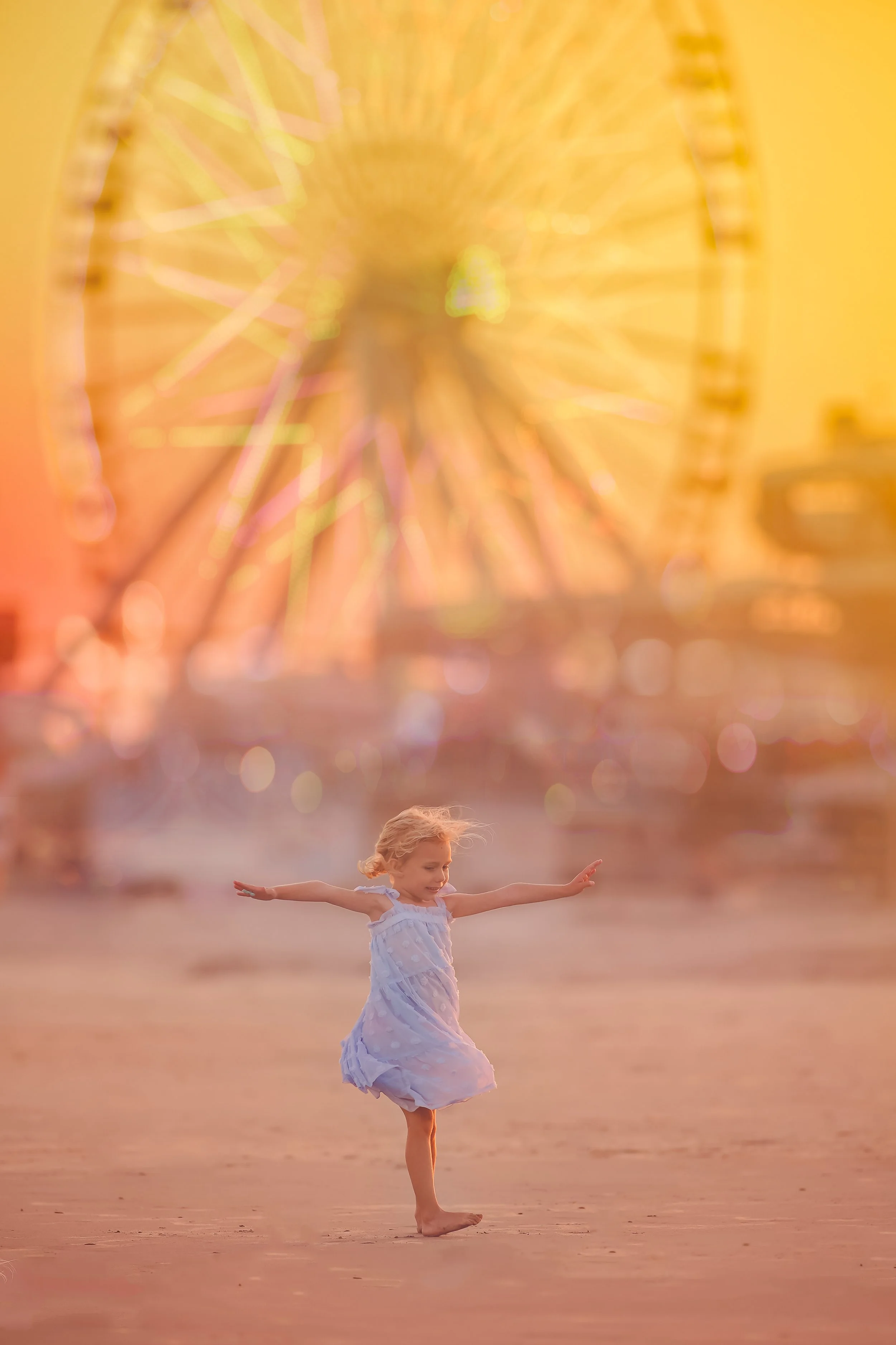 Girl spinning in the sand with the rides at Morey’s Pier behind her in Wildwood New Jersey