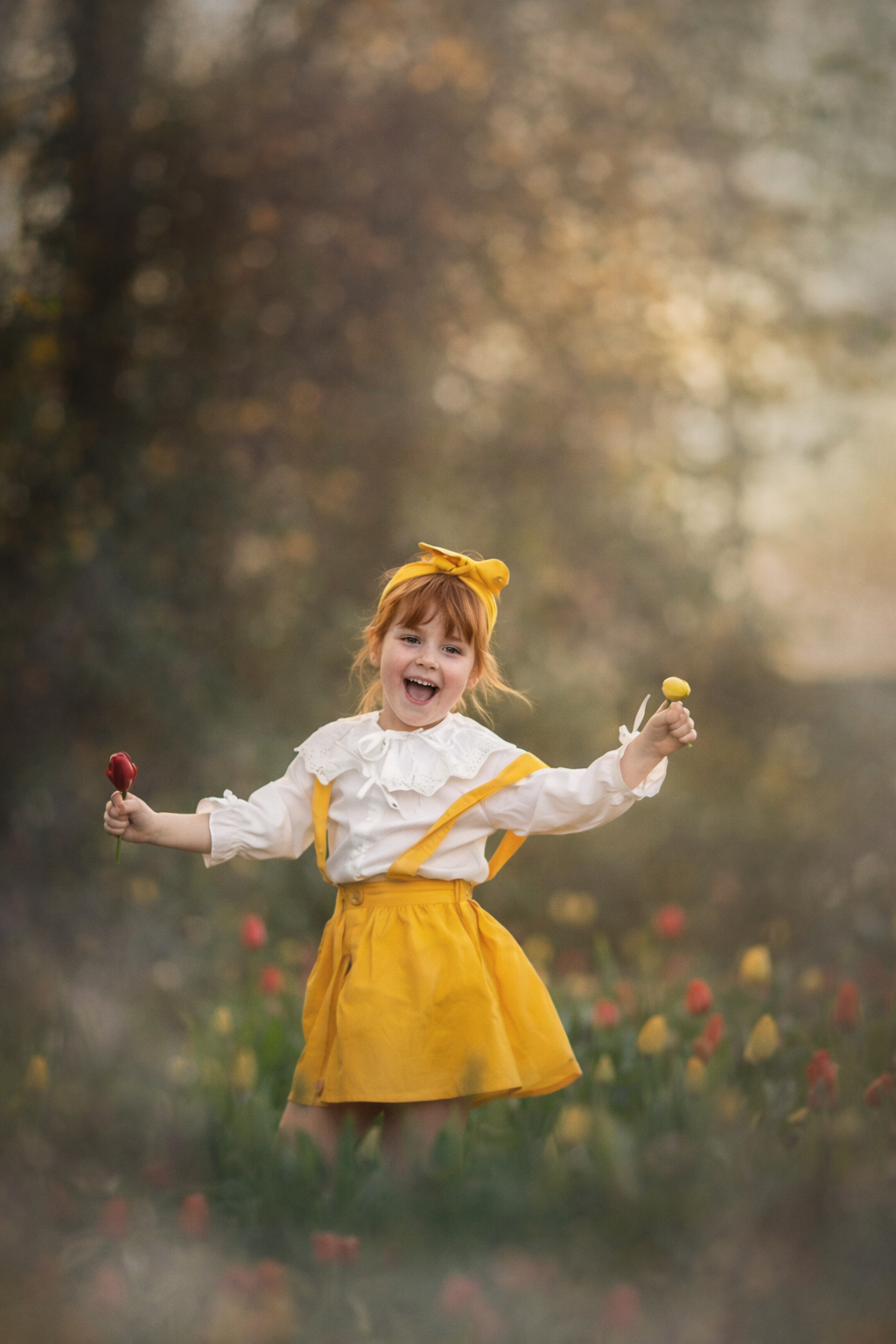 Photographer’s daughter smiling in a tulip field, holding fresh tulips during a spring portrait session in South Jersey.