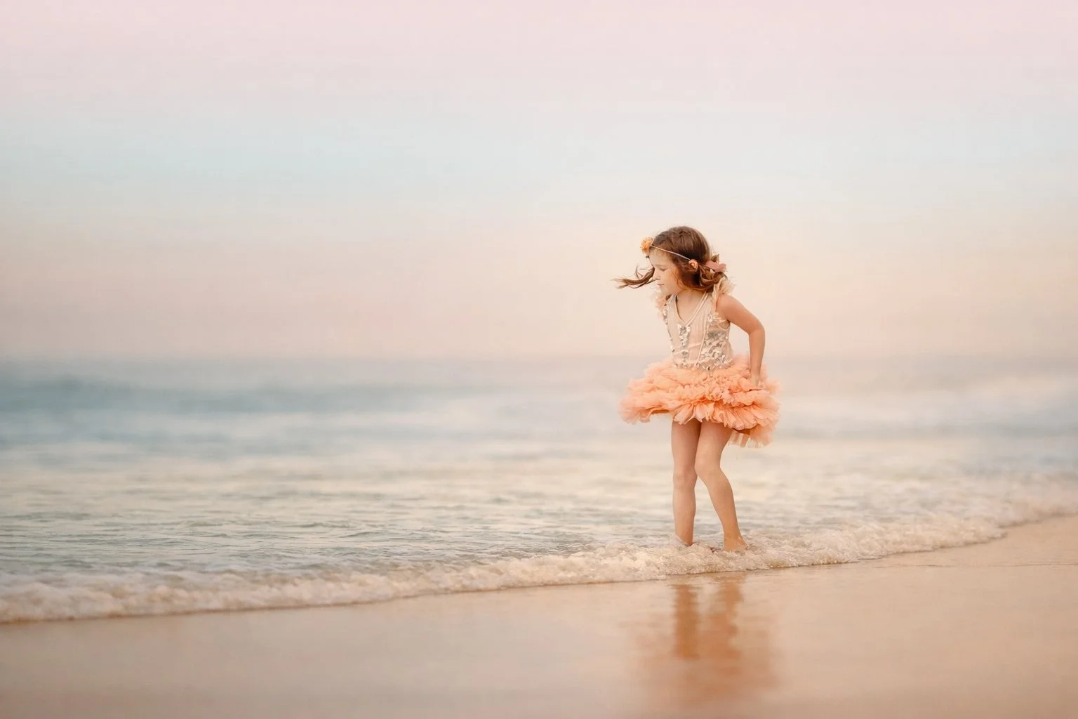 Child portrait of a young girl standing on the beach in Ocean City, New Jersey, looking out at the water during a peaceful Jersey Shore session.