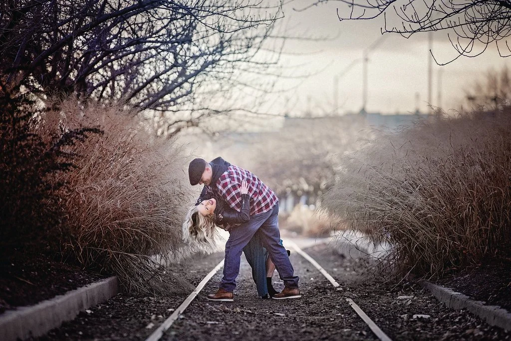 A playful moment as an engaged couple laughs together during a dip at Race Street Pier, with her smiling brightly