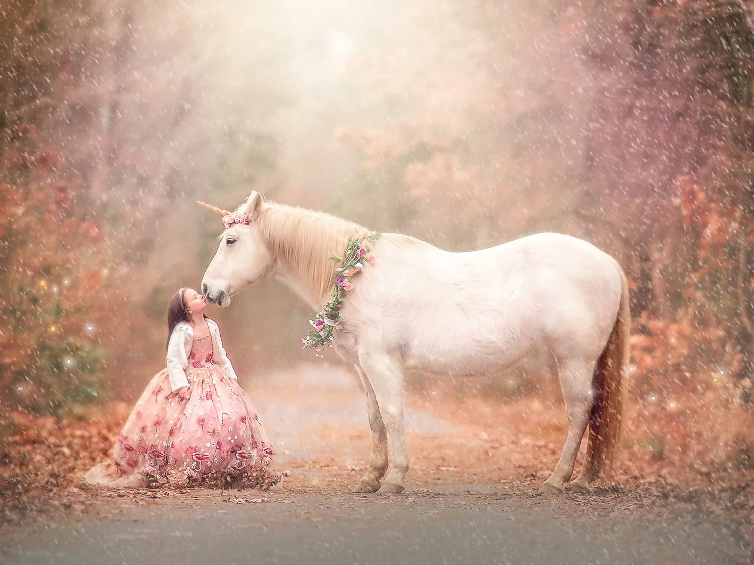 A young girl gently kissing a unicorn during a winter unicorn portrait session, surrounded by soft seasonal light.