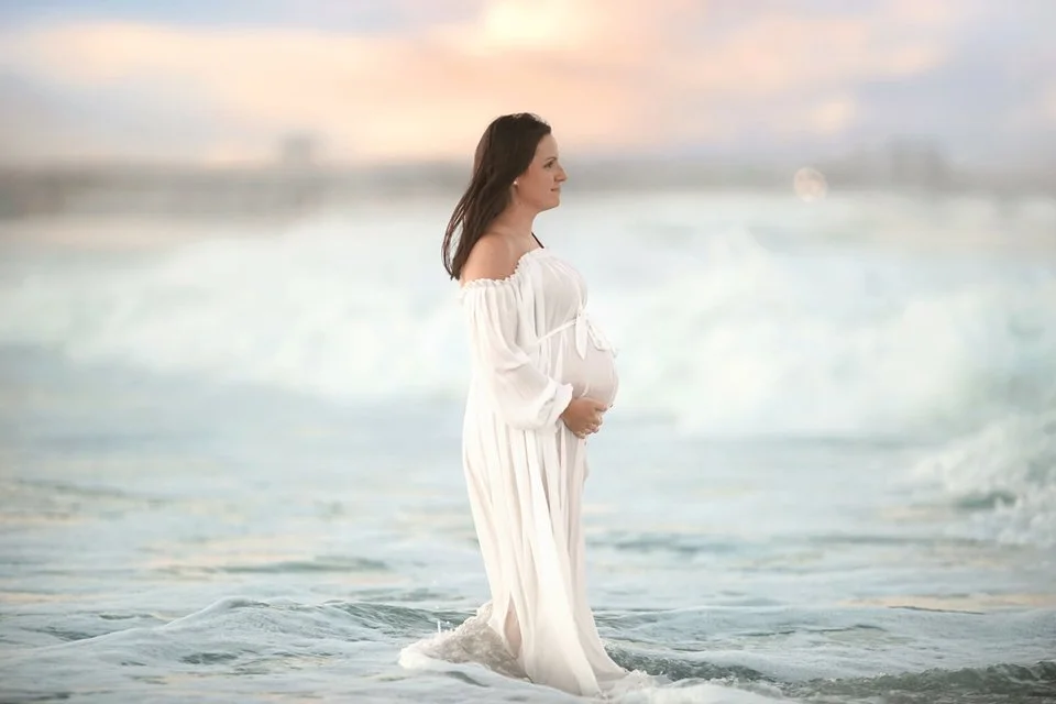 Pregnant mother standing in the ocean during a maternity photography session in Ocean City NJ