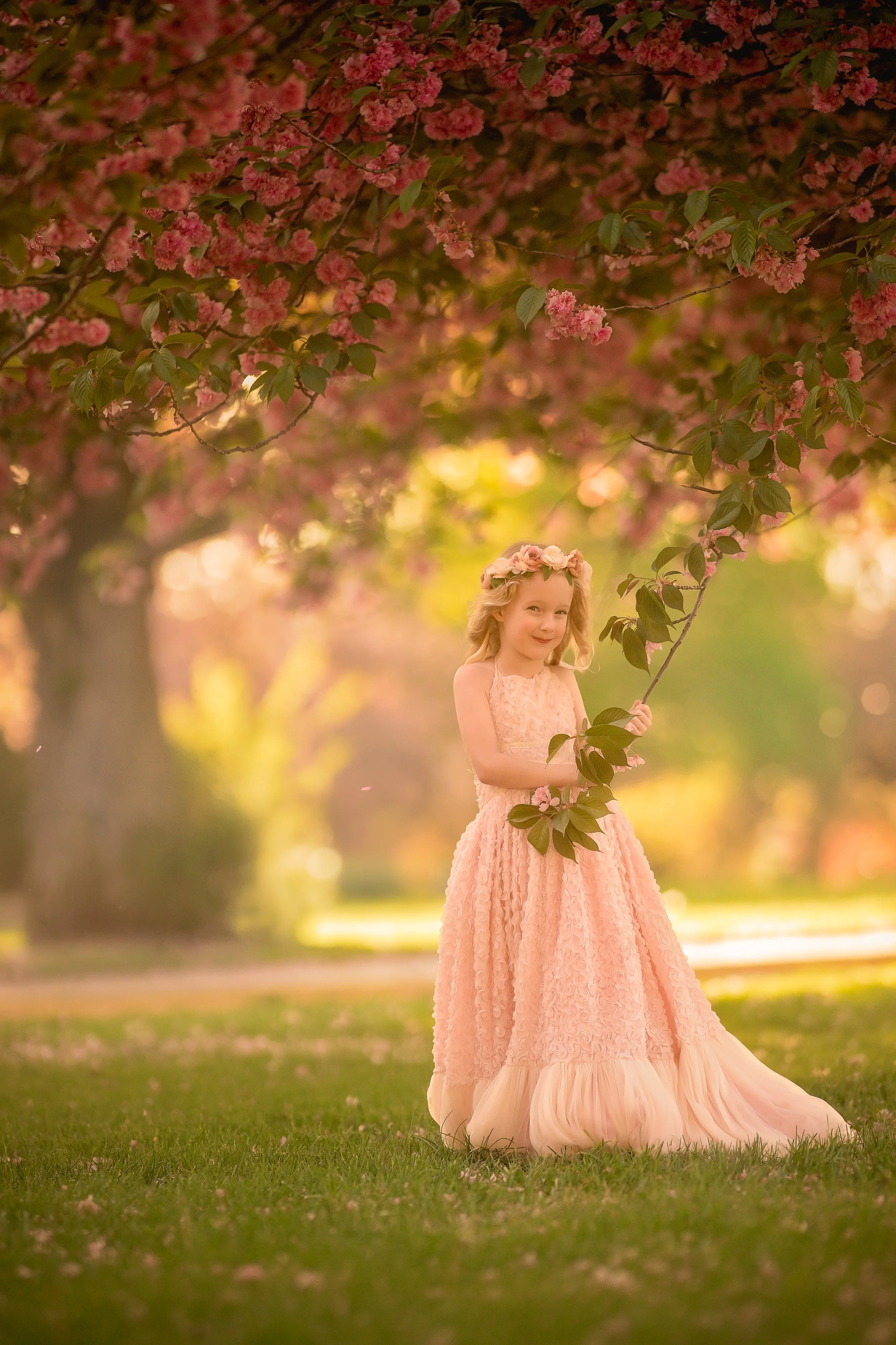 Portrait of a young girl holding flowers during a golden hour family photography session in Cherry Hill, New Jersey.