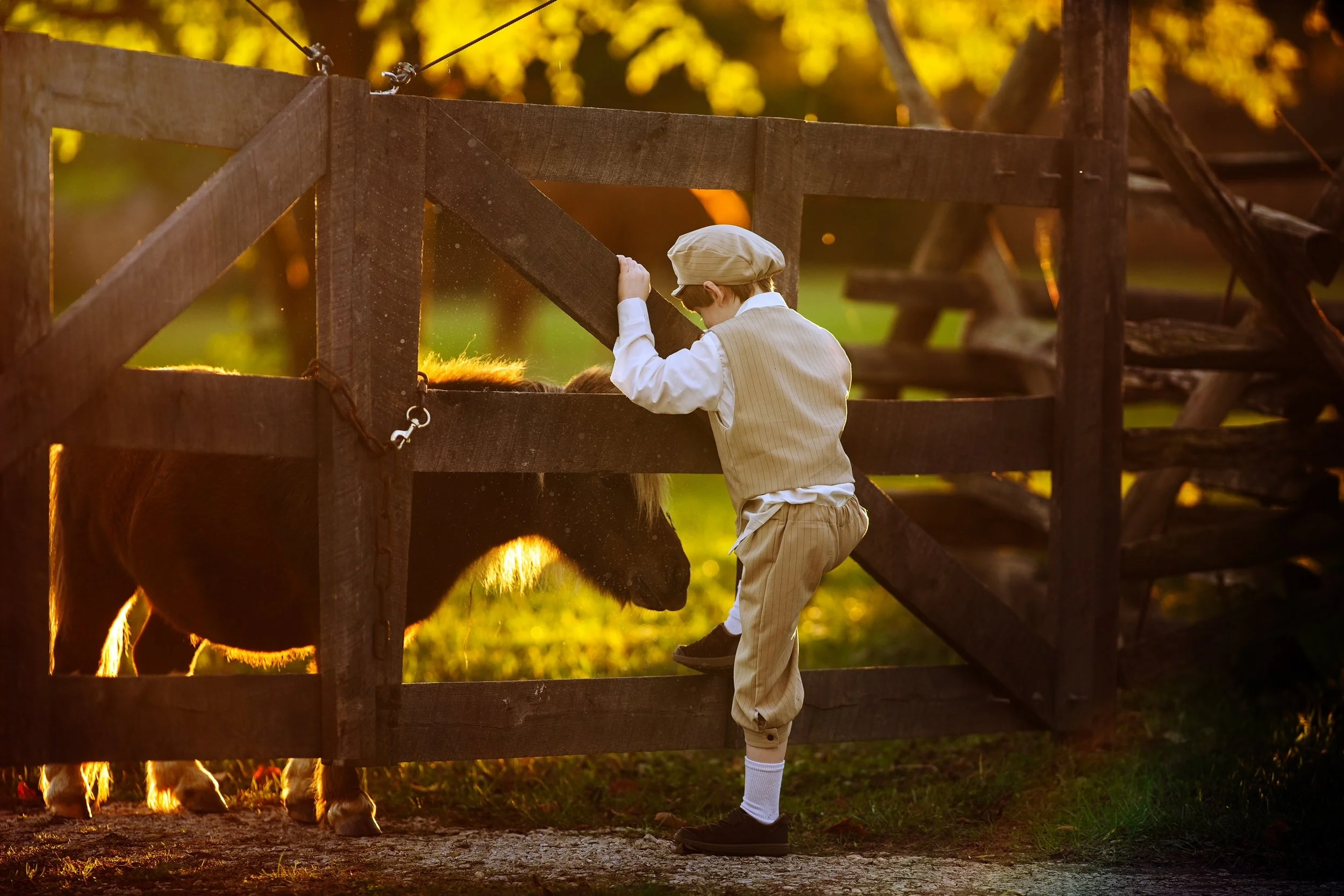 Little boy photographed in soft natural light wearing a vintage-inspired outfit