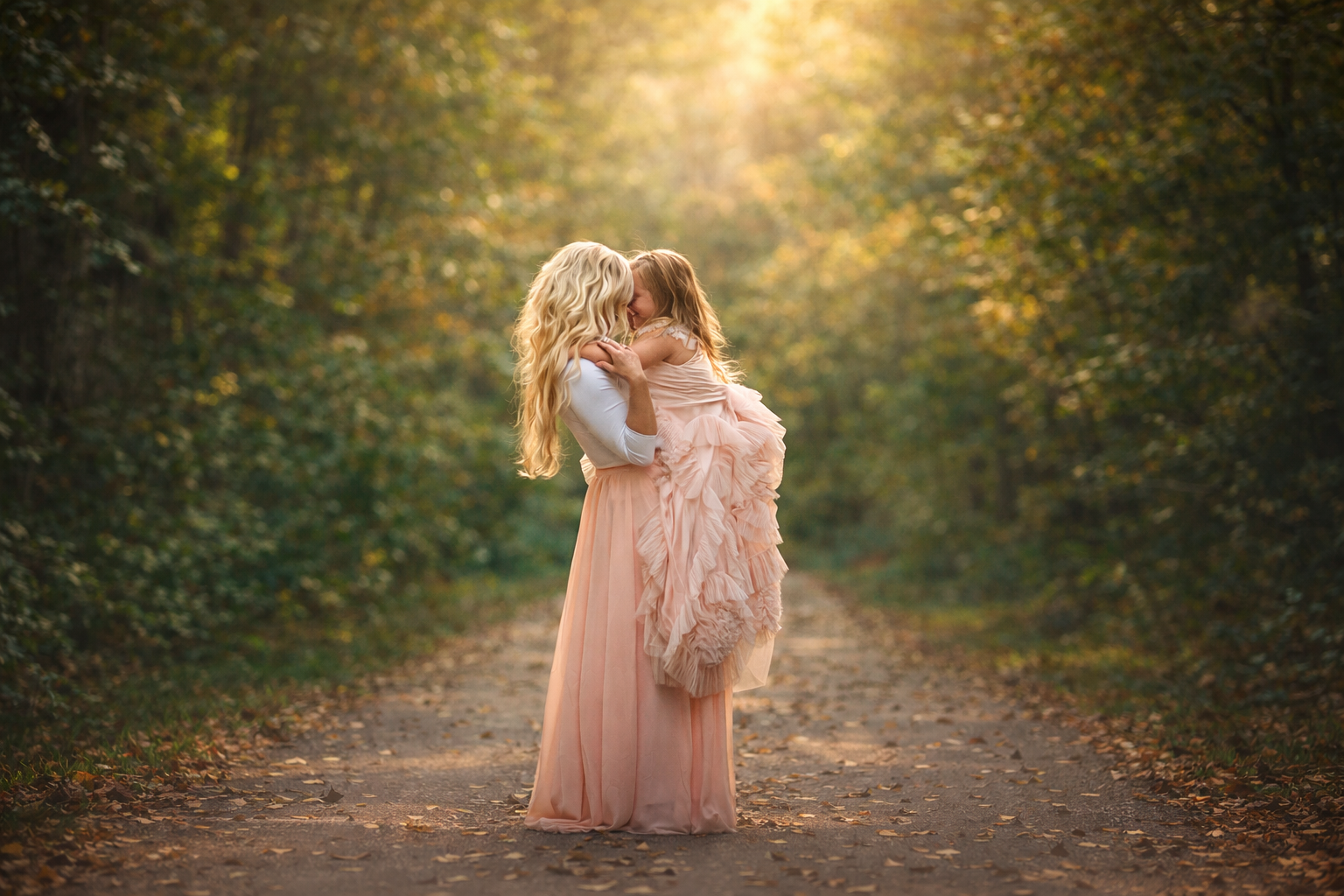A mother and her daughter embracing in warm golden light during a fine art family session in South Jersey