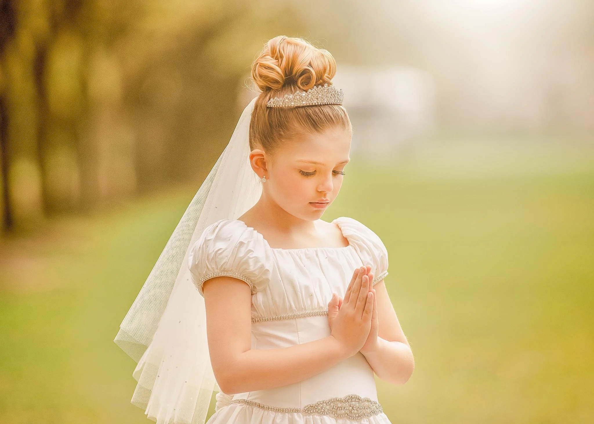 Young girl praying during her First Holy Communion portrait session photographed by a Philadelphia family photographer.