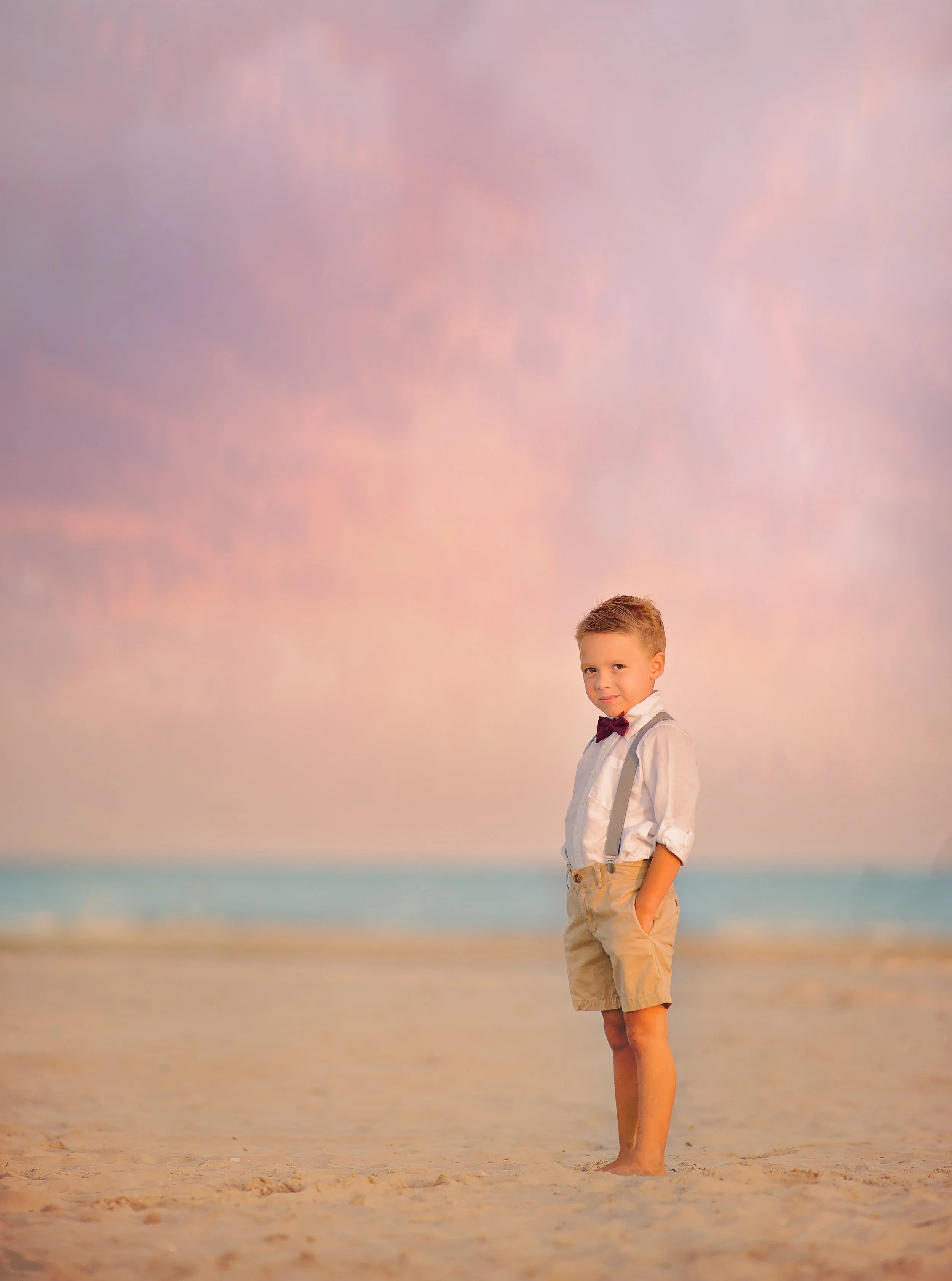 Boy posing for the camera during a beach portrait session in Wildwood New Jersey photographed by a Jersey Shore family photographer.
