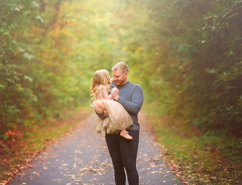 Father and daughter sharing a sweet moment during an outdoor family maternity photography session in South Jersey.