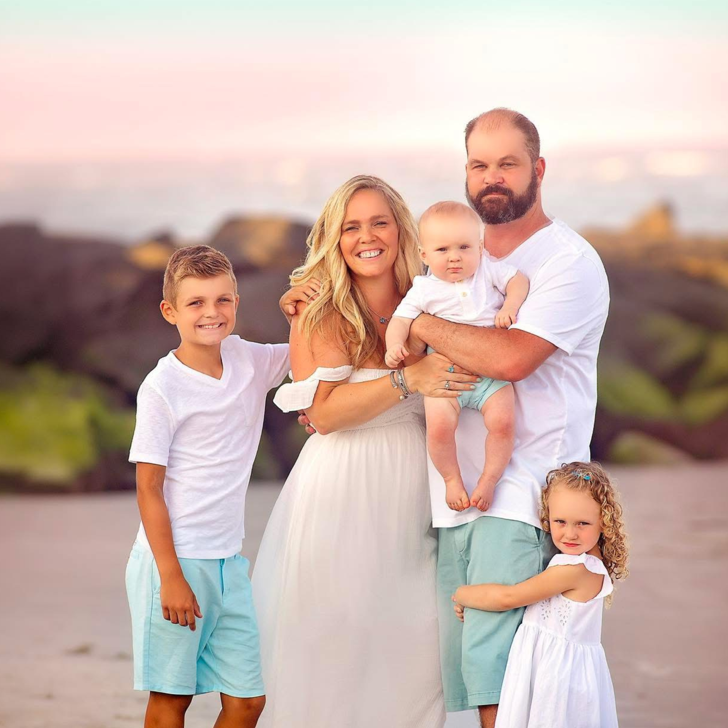 Gorgeous portrait of family in pastels and smiling with a baby at the Jersey Shore
