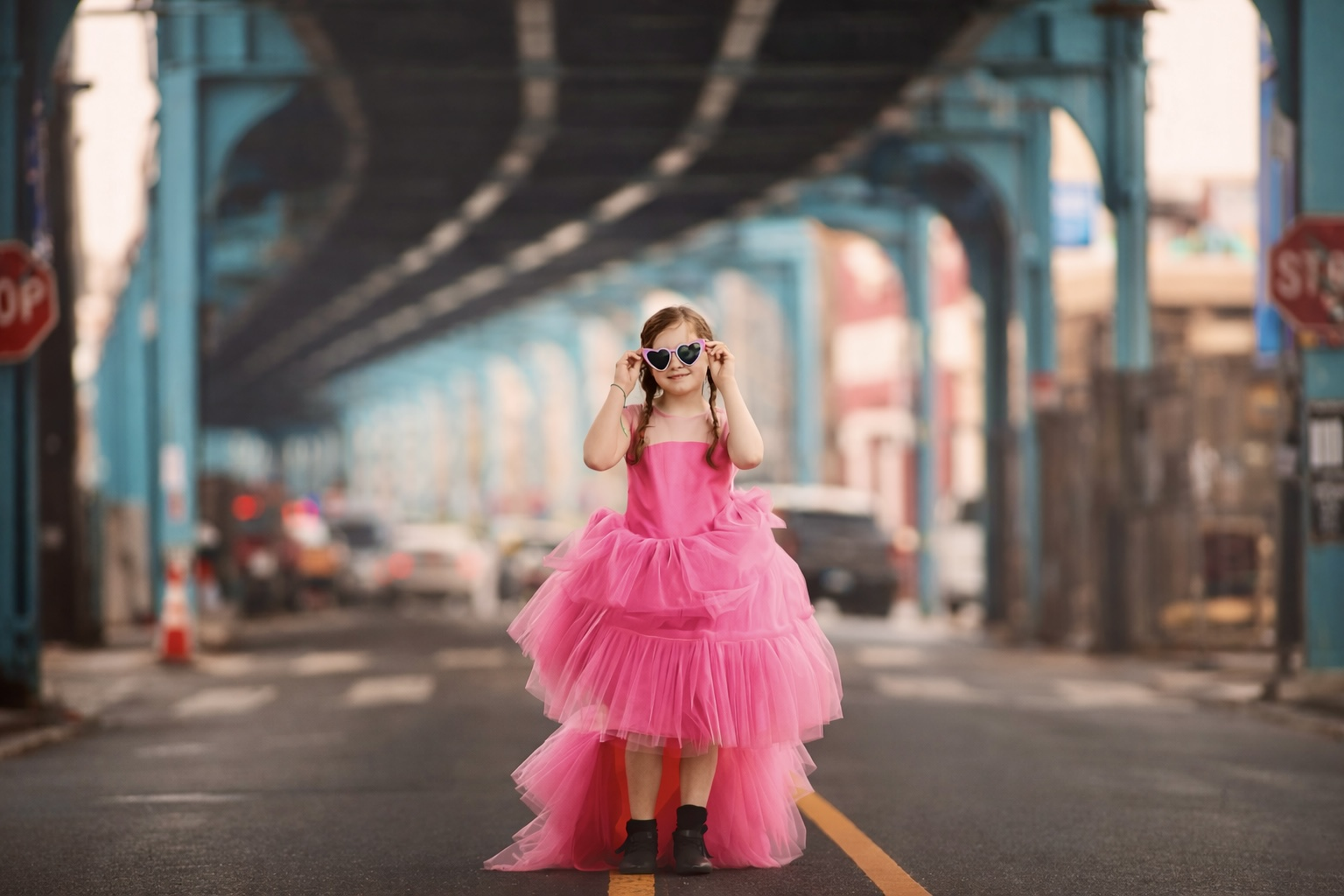 Young girl in a pink dress photographed under the El in Philadelphia during a family photography session.