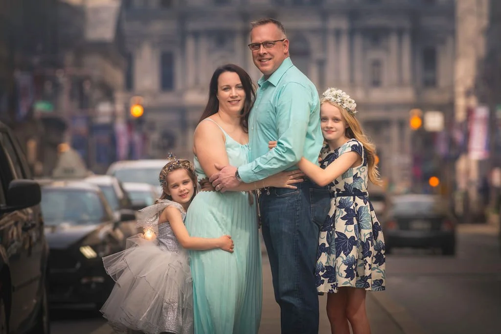 A close-up portrait of a family posing together during a family session on Broad Street in Philadelphia.