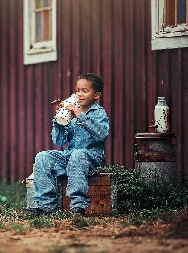 Child sipping from a vintage milk bottle during a fine art farm portrait session in South Jersey.