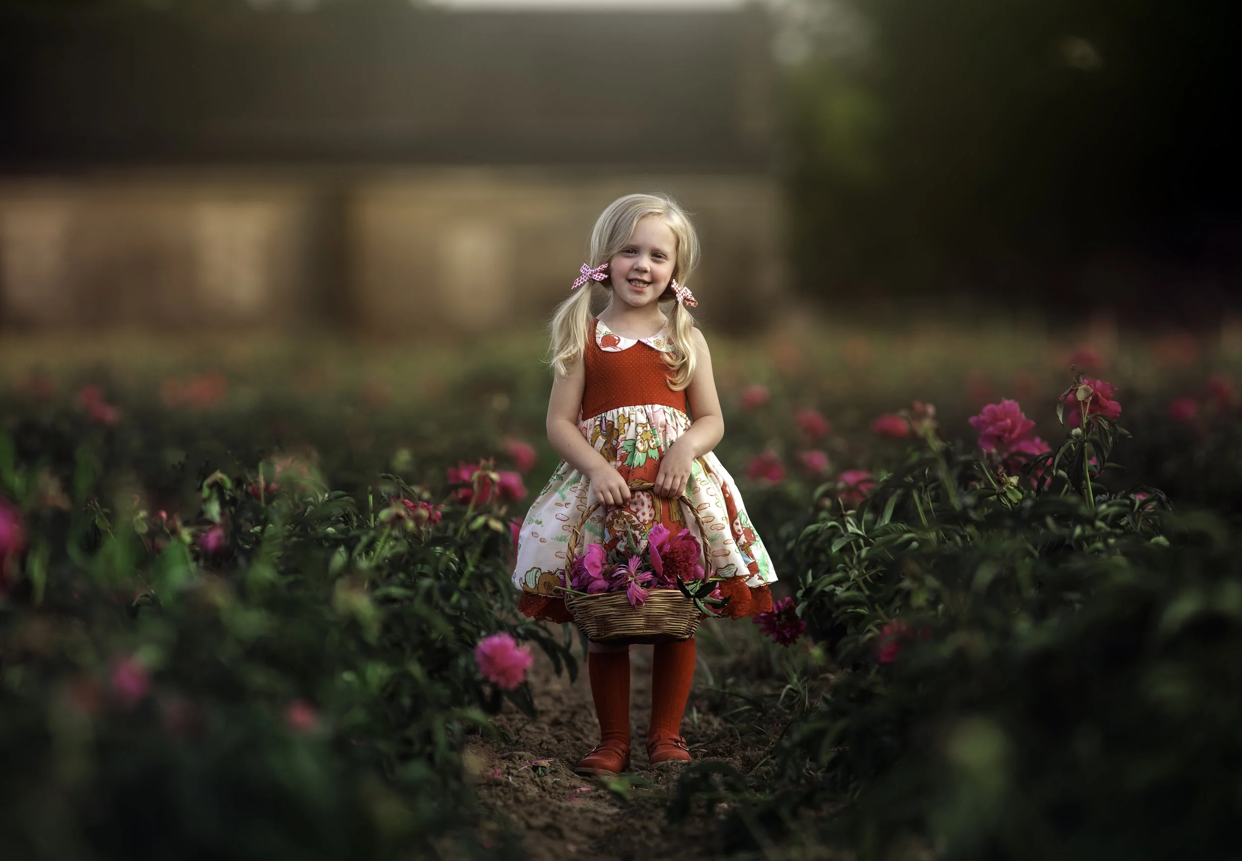 Girl smiling holding basket of flowers during South Jersey portrait session